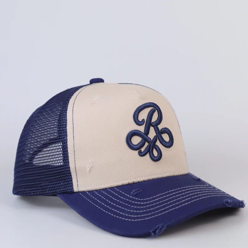 Cream front and navy mesh trucker cap with raised navy monogram and distressed brim