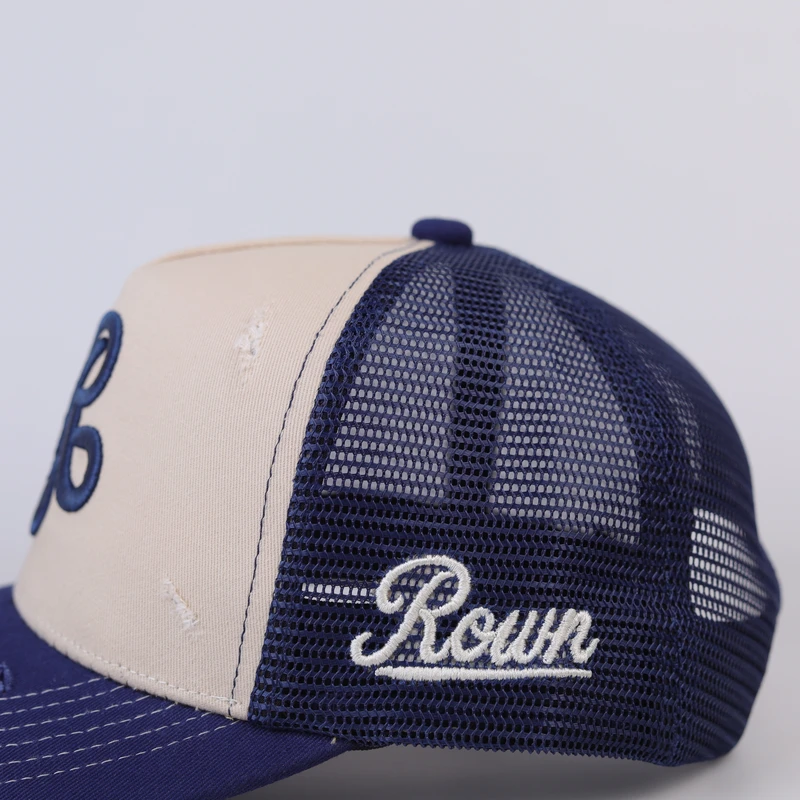 Close-up of cream front panel, navy mesh and secondary side lettering