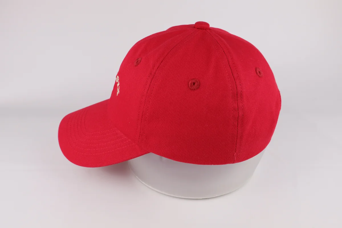 Side view showing red casual baseball cap crown and curved visor
