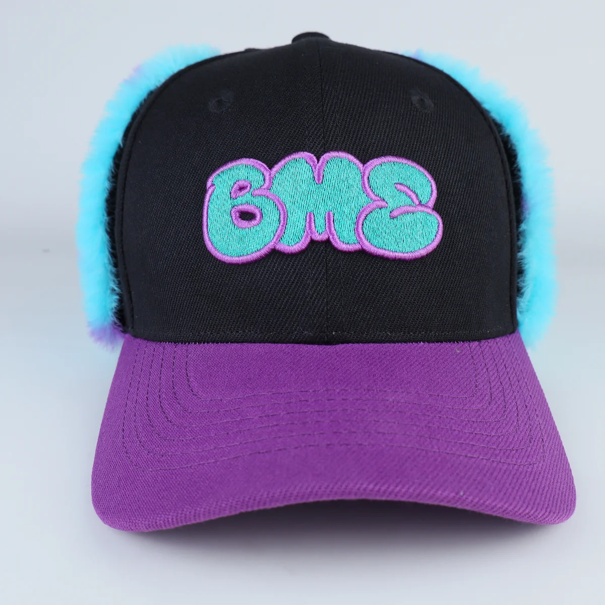 Detail angle of novelty baseball cap with fuzzy turquoise spotted panel
